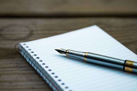 Bloc notes posé sur une table avec un stylo