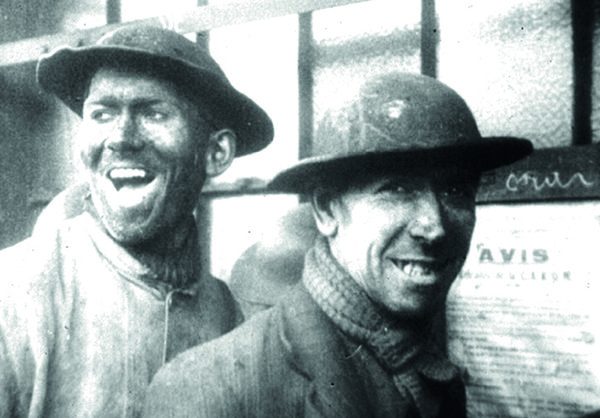 Portrait de deux mineurs très souriants.