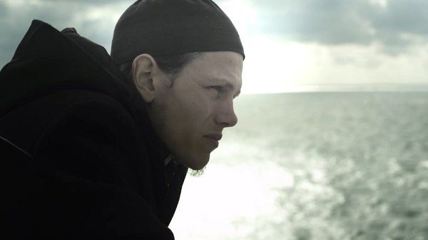 Portrait d'un jeune homme de profil regardant la mer