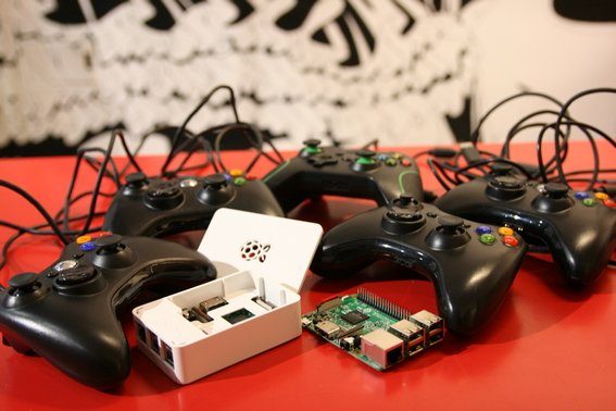 Une Recalbox et des manettes de console sur une table, devant une fresque en noir et blanc