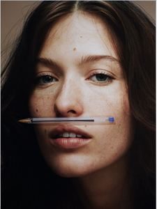 jeune femme avec un stylo en guise de moustache