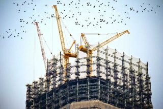 Des grues de chantier au somment d'un bâtiment en construction